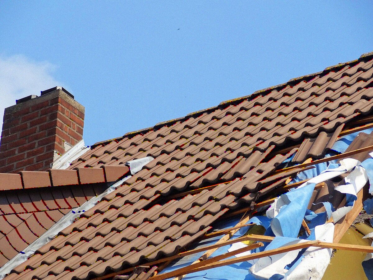 A tile roof with storm damage and debris, of the kind common on Southern California housing